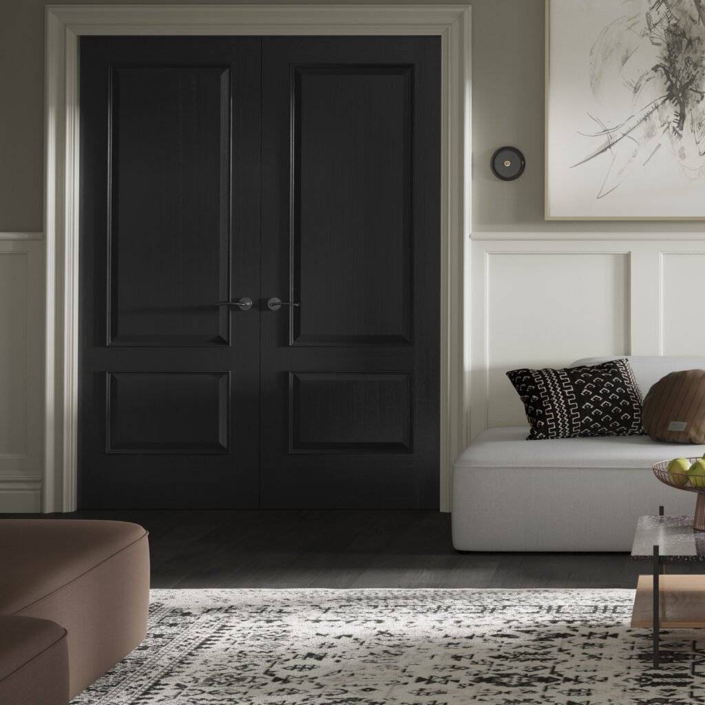 Modern interior with a black door, white sofa, and abstract art on a gray wall.